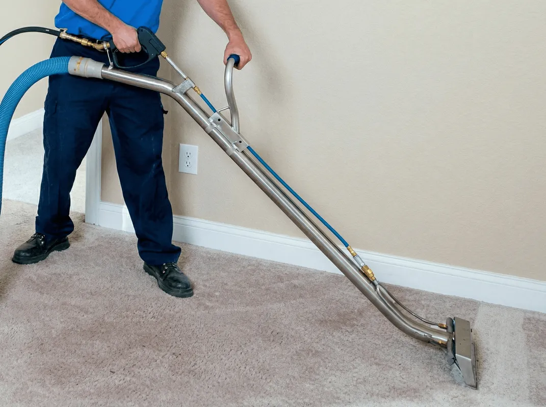 Professional operating a liquid removal machine on a carpeted floor in Cambridge, MA